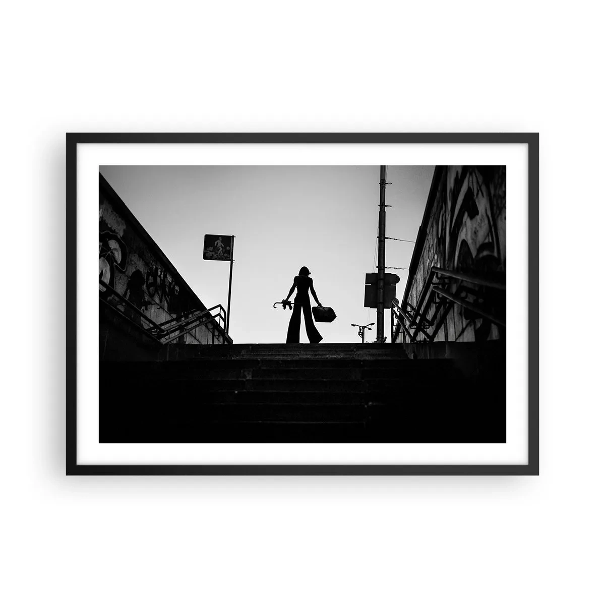 Poster in einem schwarzem Rahmen - Eine Frauenfigur auf der Treppe in Schwarzweiß mit dynamischer Atmosphäre - 70x50cm - Städtisches Wandern - Moderne Wanddekoration für Wohnzimmer und Schlafzimmer ARTTOR
