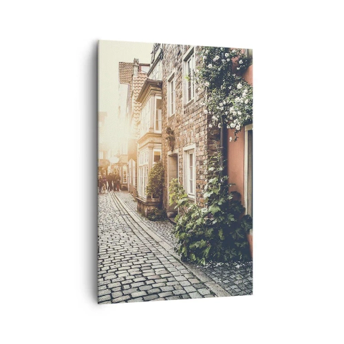 Bild auf Leinwand - Leinwandbild - Eine charmante Straße mit Steinpflaster und Blumen - 80x120cm - Rosenallee im rosa Schein - Moderne Wanddekoration für Wohnzimmer und Schlafzimmer ARTTOR