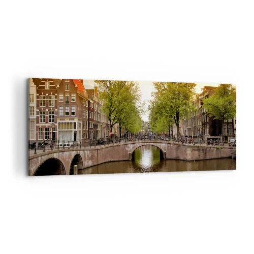 Bild auf Leinwand - Leinwandbild - Ein Kanal in Amsterdam, umgeben von historischen Mietshäusern - 120x50cm - Mit dem Boot oder mit dem Fahrrad? - Moderne Wanddekoration für Wohnzimmer und Schlafzimmer ARTTOR