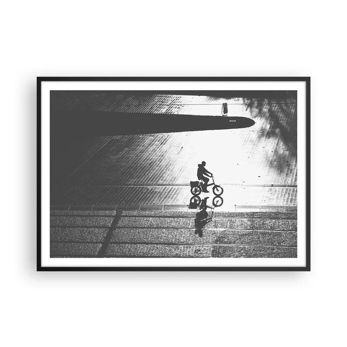 Poster in einem schwarzem Rahmen - Schwarz-weiße Silhouette eines Radfahrers auf einer nassen Straße - 100x70cm - Vor sich hin durch die Stadt - Moderne Wanddekoration für Wohnzimmer und Schlafzimmer ARTTOR