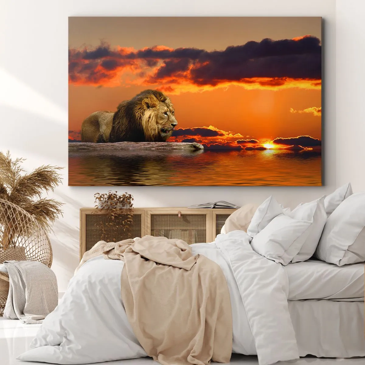 Bild auf Leinwand - Leinwandbild - Ein Löwe ruht bei Sonnenuntergang vor einem dramatischen Himmel am Wasser. - 100x70cm - König der Natur - Moderne Wanddekoration für Wohnzimmer und Schlafzimmer ARTTOR
