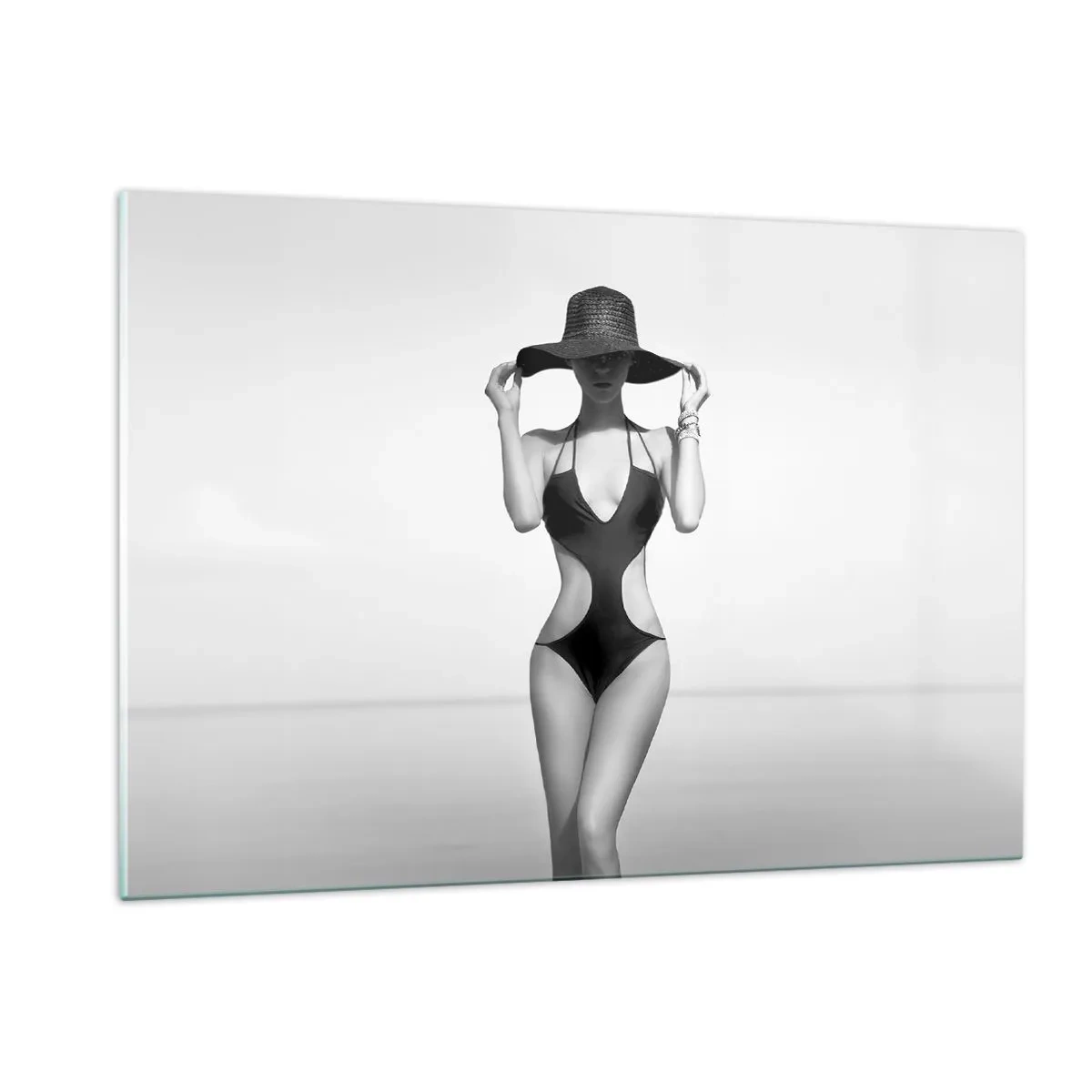 Glasbild - Bild auf glas - Eine Frau in einem schwarzen Badeanzug und Hut vor dem Meer - 120x80cm - Mein Name ist: Eleganz - Moderne Wanddekoration für Wohnzimmer und Schlafzimmer ARTTOR