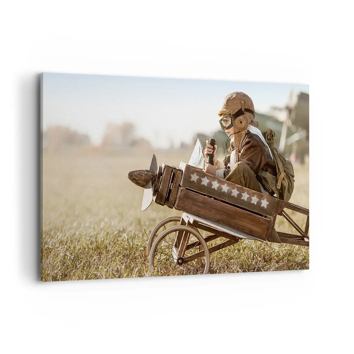 Bild auf Leinwand - Leinwandbild - Ein Kind in einem Spielzeugflugzeug mit einem Feld im Hintergrund - 120x80cm - Start in Richtung eines Traums - Moderne Wanddekoration für Wohnzimmer und Schlafzimmer ARTTOR