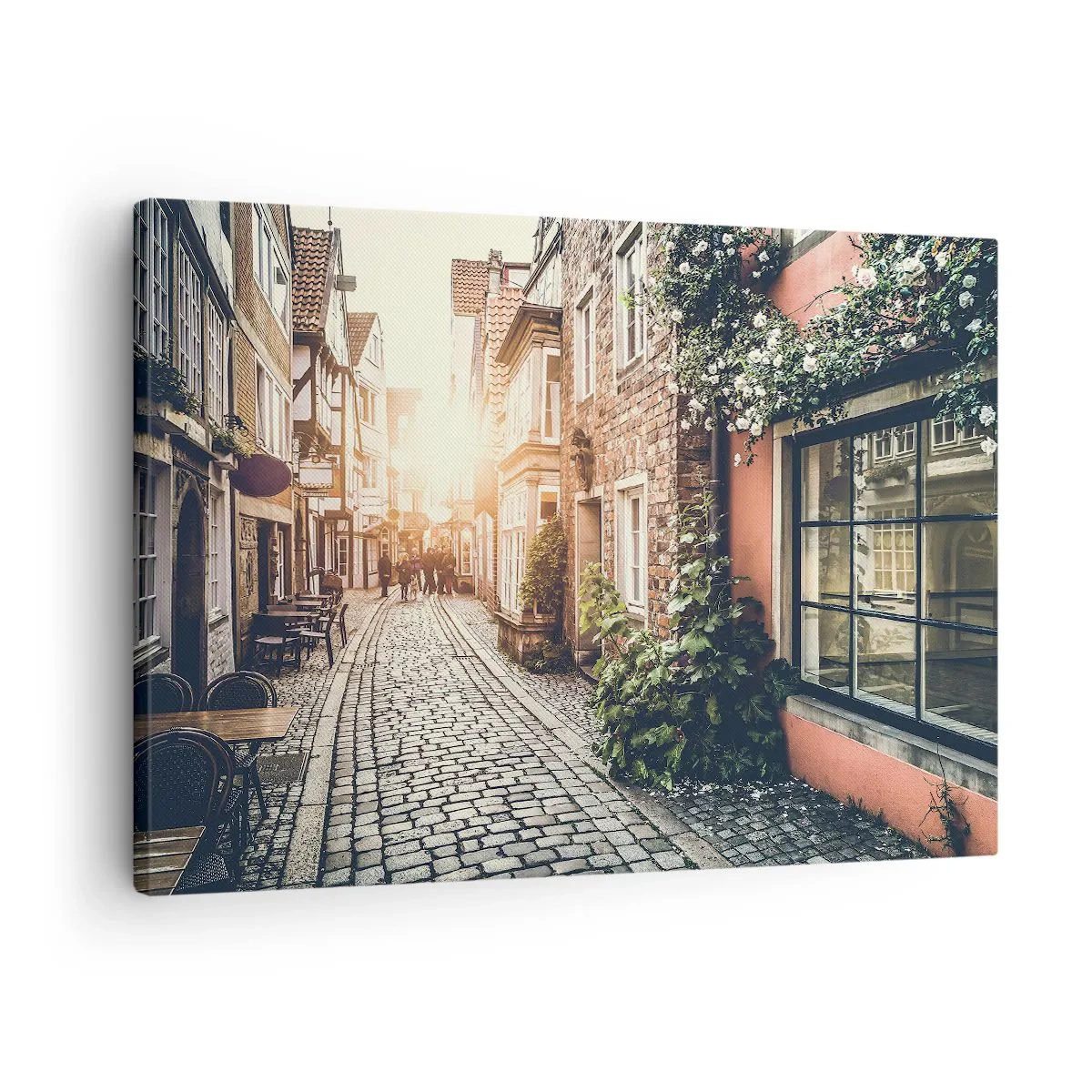 Bild auf Leinwand - Leinwandbild - Eine charmante Straße mit Steinpflaster und Blumen - 70x50cm - Rosenallee im rosa Schein - Moderne Wanddekoration für Wohnzimmer und Schlafzimmer ARTTOR