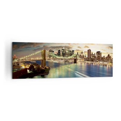 Bild auf Leinwand - Leinwandbild - Eine beleuchtete Brücke mit der Stadt im Hintergrund, deren Lichter sich im Wasser spiegeln. - 160x50cm - Ein heller Abend über Manhattan - Moderne Wanddekoration für Wohnzimmer und Schlafzimmer ARTTOR