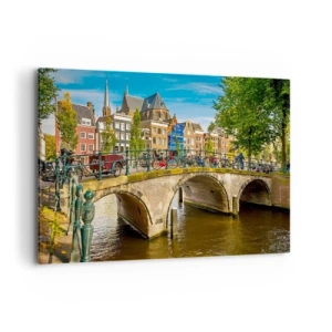 Bild auf Leinwand - Leinwandbild - Ein malerischer Kanal mit einer Brücke in Amsterdam - 100x70cm - Frühling am Kanal - Moderne Wanddekoration für Wohnzimmer und Schlafzimmer ARTTOR