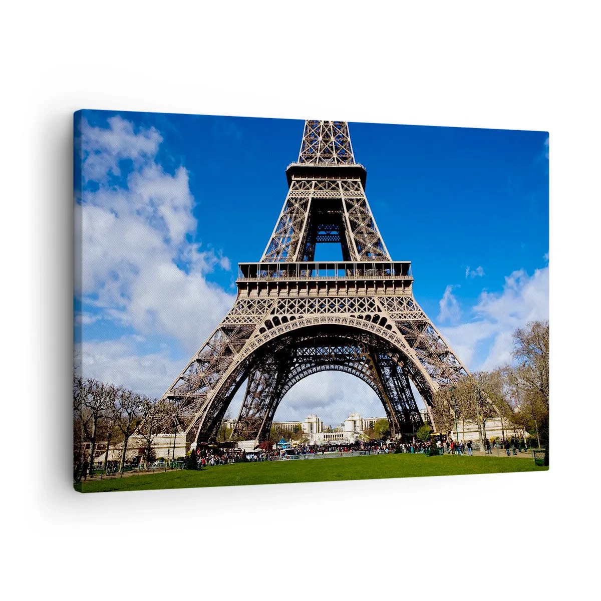 Bild auf Leinwand - Leinwandbild - Der Eiffelturm vor dem Hintergrund eines blauen Himmels und eines grünen Parks - 70x50cm - Ganz Paris zu ihren Füßen - Moderne Wanddekoration für Wohnzimmer und Schlafzimmer ARTTOR