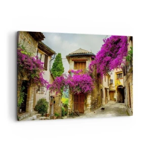 Bild auf Leinwand - Leinwandbild - Eine Steinstraße mit rosa Blumen und Häusern - 100x70cm - Unter einem Blumendach - Moderne Wanddekoration für Wohnzimmer und Schlafzimmer ARTTOR