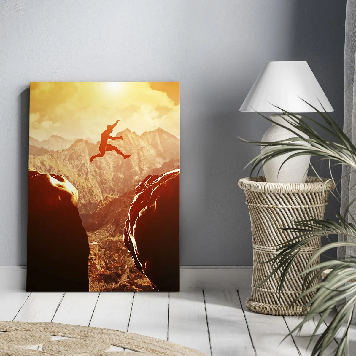 Bild auf Leinwand - Leinwandbild - Eine Figur springt zwischen Felsen mit Bergen im Hintergrund - 70x100cm - Grenzen überschreiten - Moderne Wanddekoration für Wohnzimmer und Schlafzimmer ARTTOR