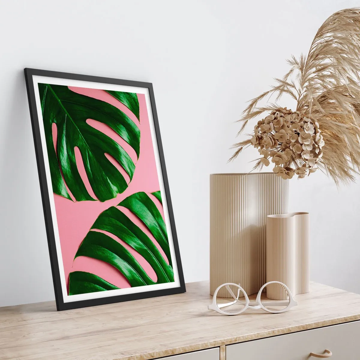 Poster in einem schwarzem Rahmen - Monstera-Blätter auf rosa Hintergrund im minimalistischen Stil - 50x70cm - Rendezvous im Grünen - Moderne Wanddekoration für Wohnzimmer und Schlafzimmer ARTTOR