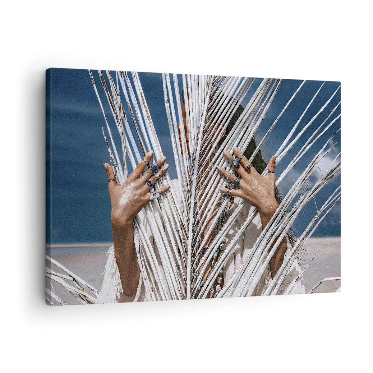 Bild auf Leinwand - Leinwandbild - Eine Frau, versteckt hinter Palmblättern, mit Ringen an den Händen. - 70x50cm - Das Mädchen des Schamanen? - Moderne Wanddekoration für Wohnzimmer und Schlafzimmer ARTTOR