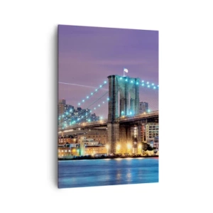 Bild auf Leinwand - Leinwandbild - Brooklyn Bridge bei Nacht mit der beleuchteten Stadt im Hintergrund - 70x100cm - Seit vielen Jahren die Brooklyn Bridge - Moderne Wanddekoration für Wohnzimmer und Schlafzimmer ARTTOR