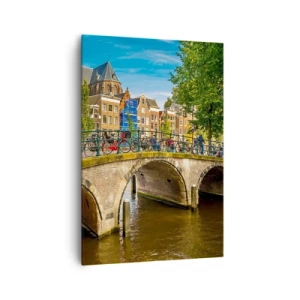 Bild auf Leinwand - Leinwandbild - Ein malerischer Kanal mit einer Brücke in Amsterdam - 70x100cm - Frühling am Kanal - Moderne Wanddekoration für Wohnzimmer und Schlafzimmer ARTTOR