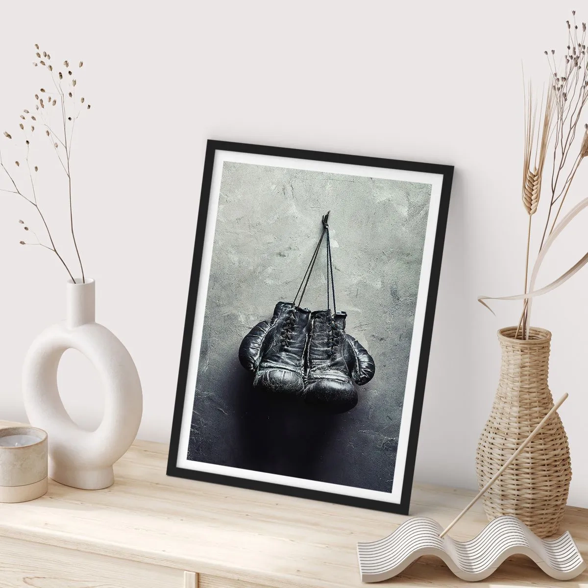 Poster in einem schwarzem Rahmen - Schwarze Boxhandschuhe hängen an einer Schnur - 50x70cm - Zeit des Kampfes und Zeit des Friedens - Moderne Wanddekoration für Wohnzimmer und Schlafzimmer ARTTOR