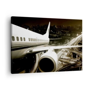 Bild auf Leinwand - Leinwandbild - Ein Flugzeug über einer nächtlichen Stadt mit beleuchteten Autobahnen - 70x50cm - In die Nacht fliegen - Moderne Wanddekoration für Wohnzimmer und Schlafzimmer ARTTOR