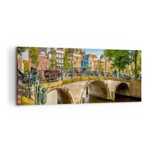 Bild auf Leinwand - Leinwandbild - Ein malerischer Kanal mit einer Brücke in Amsterdam - 120x50cm - Frühling am Kanal - Moderne Wanddekoration für Wohnzimmer und Schlafzimmer ARTTOR