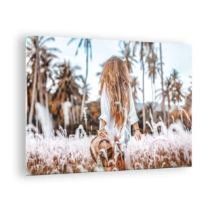 Glasbild - Bild auf glas - Eine Frau im Gras mit einem Hut in der Hand vor einem Hintergrund aus Palmen - 70x50cm - Geboren aus Grasflaum - Moderne Wanddekoration für Wohnzimmer und Schlafzimmer ARTTOR