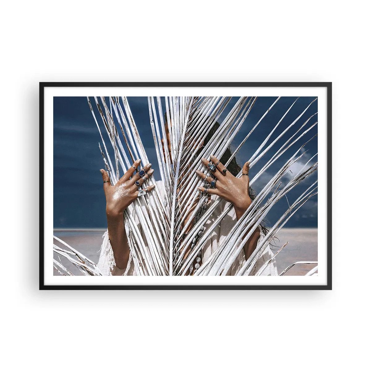 Poster in einem schwarzem Rahmen - Eine Frau, versteckt hinter Palmblättern, mit Ringen an den Händen. - 100x70cm - Das Mädchen des Schamanen? - Moderne Wanddekoration für Wohnzimmer und Schlafzimmer ARTTOR