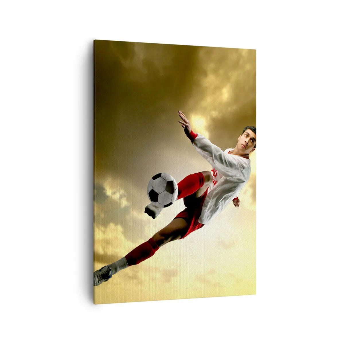 Bild auf Leinwand - Leinwandbild - Ein Fußballspieler in einem dynamischen Sprung kickt den Ball in den Himmel - 70x100cm - Fußballhimmel - Moderne Wanddekoration für Wohnzimmer und Schlafzimmer ARTTOR