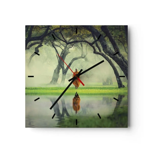 Wanduhr - Glasuhr - Ein Mönch in einer orangefarbenen Robe in einem Wald mit nebligem Hintergrund und Spiegelung im Wasser. - 30x30cm - Auf dem Weg zur Erleuchtung - Moderne Wanddekoration für Wohnzimmer und Schlafzimmer ARTTOR