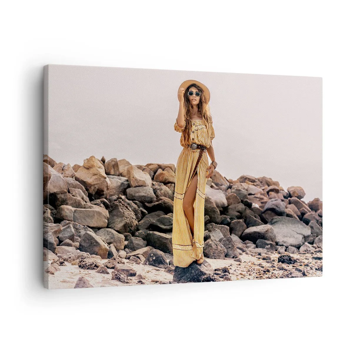 Bild auf Leinwand - Leinwandbild - Eine Frau im Boho-Stil vor einem felsigen Strandhintergrund - 70x50cm - Die Magie der Steine - Moderne Wanddekoration für Wohnzimmer und Schlafzimmer ARTTOR