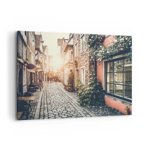 Bild auf Leinwand - Leinwandbild - Eine charmante Straße mit Steinpflaster und Blumen - 100x70cm - Rosenallee im rosa Schein - Moderne Wanddekoration für Wohnzimmer und Schlafzimmer ARTTOR