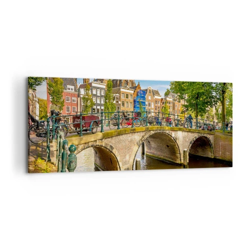 Bild auf Leinwand - Leinwandbild - Ein malerischer Kanal mit einer Brücke in Amsterdam - 120x50cm - Frühling am Kanal - Moderne Wanddekoration für Wohnzimmer und Schlafzimmer ARTTOR