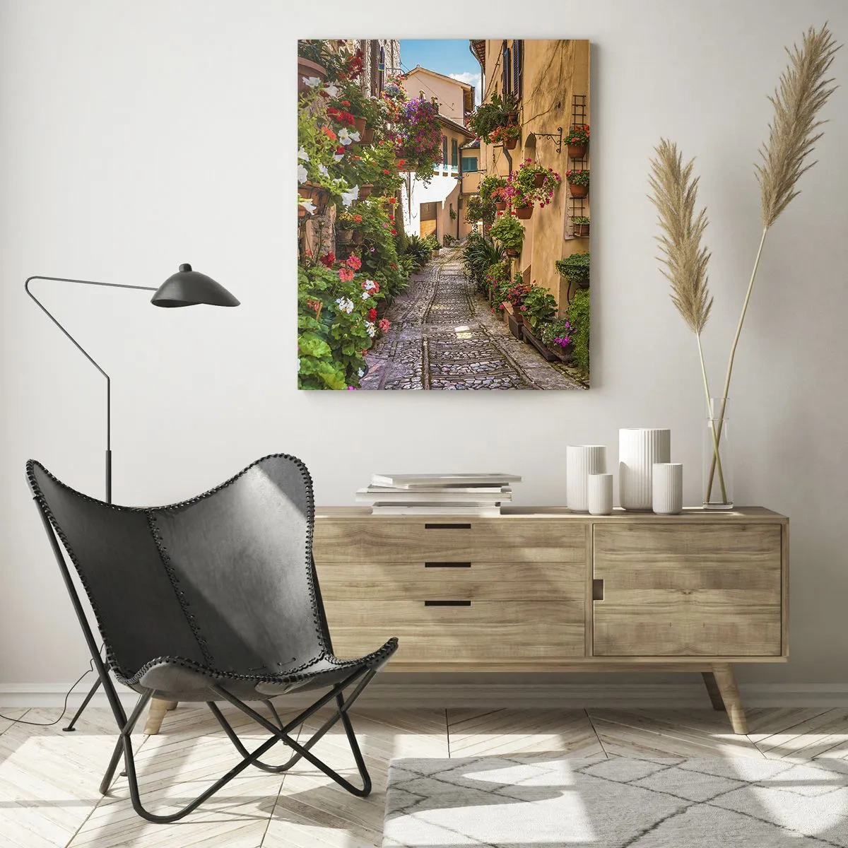Glasbild - Bild auf glas - Eine charmante italienische Gasse mit Topfblumen und einer Kopfsteinpflasterstraße - 50x70cm - Italienische Gasse - Moderne Wanddekoration für Wohnzimmer und Schlafzimmer ARTTOR