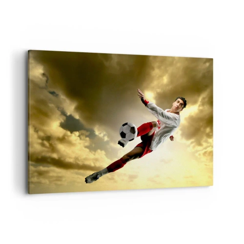 Bild auf Leinwand - Leinwandbild - Ein Fußballspieler in einem dynamischen Sprung kickt den Ball in den Himmel - 100x70cm - Fußballhimmel - Moderne Wanddekoration für Wohnzimmer und Schlafzimmer ARTTOR