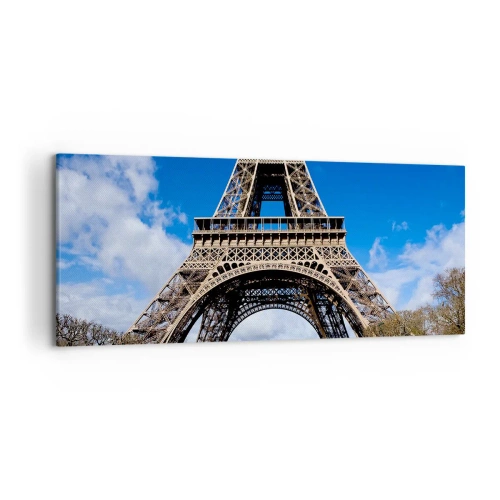 Bild auf Leinwand - Leinwandbild - Der Eiffelturm vor dem Hintergrund eines blauen Himmels und eines grünen Parks - 120x50cm - Ganz Paris zu ihren Füßen - Moderne Wanddekoration für Wohnzimmer und Schlafzimmer ARTTOR