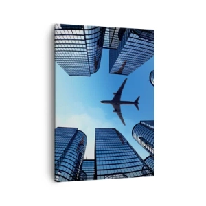 Bild auf Leinwand - Leinwandbild - Ein Flugzeug fliegt über moderne Wolkenkratzer im Stadtzentrum. - 50x70cm - Der Blick aus der Glasschlucht - Moderne Wanddekoration für Wohnzimmer und Schlafzimmer ARTTOR
