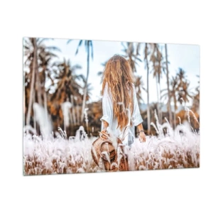 Glasbild - Bild auf glas - Eine Frau im Gras mit einem Hut in der Hand vor einem Hintergrund aus Palmen - 120x80cm - Geboren aus Grasflaum - Moderne Wanddekoration für Wohnzimmer und Schlafzimmer ARTTOR