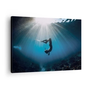 Bild auf Leinwand - Leinwandbild - Ein Taucher, der in einem Lichtstrahl unter Wasser schwimmt - 70x50cm - Tanz unter Wasser - Moderne Wanddekoration für Wohnzimmer und Schlafzimmer ARTTOR
