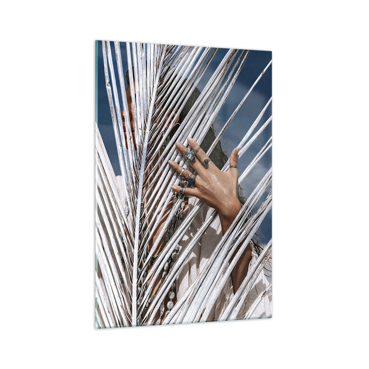 Glasbild - Bild auf glas - Eine Frau, versteckt hinter Palmblättern, mit Ringen an den Händen. - 70x100cm - Das Mädchen des Schamanen? - Moderne Wanddekoration für Wohnzimmer und Schlafzimmer ARTTOR