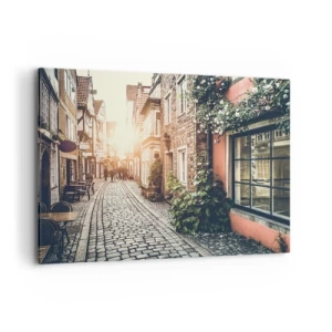 Bild auf Leinwand - Leinwandbild - Eine charmante Straße mit Steinpflaster und Blumen - 100x70cm - Rosenallee im rosa Schein - Moderne Wanddekoration für Wohnzimmer und Schlafzimmer ARTTOR