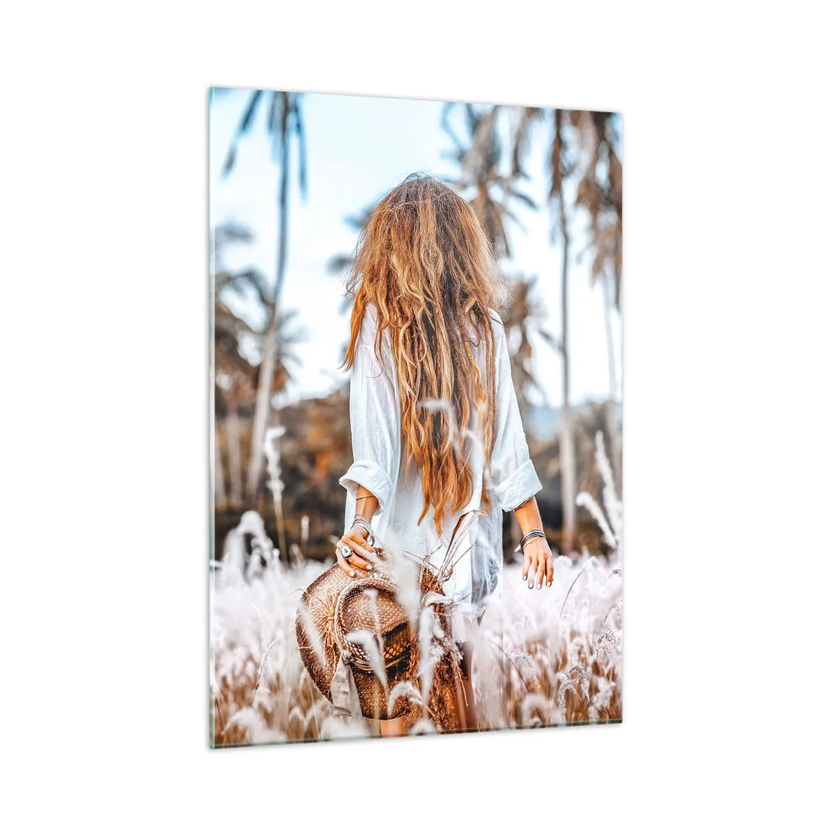 Glasbild - Bild auf glas - Eine Frau im Gras mit einem Hut in der Hand vor einem Hintergrund aus Palmen - 50x70cm - Geboren aus Grasflaum - Moderne Wanddekoration für Wohnzimmer und Schlafzimmer ARTTOR