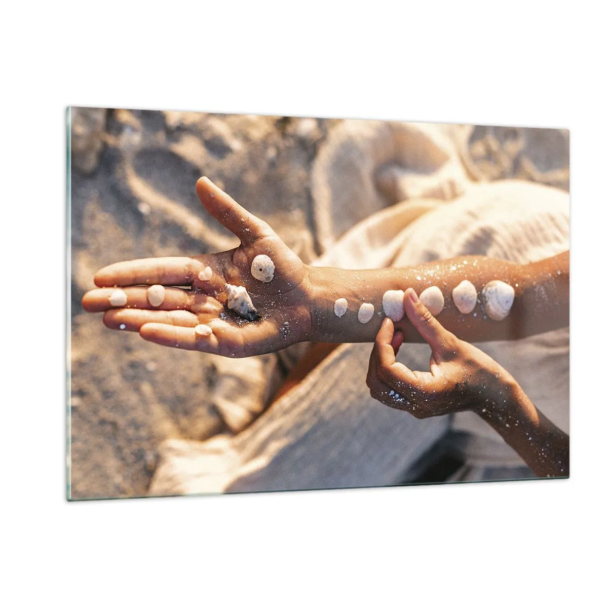 Glasbild - Bild auf glas - Kinderhände mit Muscheln auf einem Hintergrund aus Sand und Stoff - 120x80cm - Schönheit an Ihren Fingerspitzen - Moderne Wanddekoration für Wohnzimmer und Schlafzimmer ARTTOR