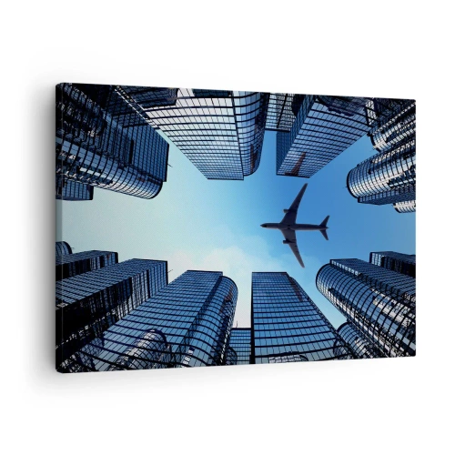 Bild auf Leinwand - Leinwandbild - Ein Flugzeug fliegt über moderne Wolkenkratzer im Stadtzentrum. - 70x50cm - Der Blick aus der Glasschlucht - Moderne Wanddekoration für Wohnzimmer und Schlafzimmer ARTTOR