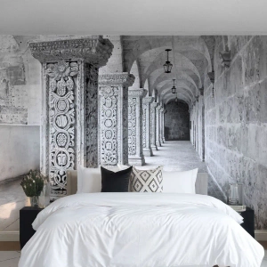 Fototapete Premium Sand - Steinsäulen mit Ornamenten in einem monochromen Kreuzgang - 100x70cm - Und wo geht’s hin...? - Moderne Wanddekoration für Wohnzimmer und Schlafzimmer ARTTOR