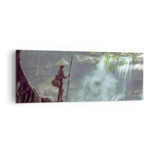Bild auf Leinwand - Leinwandbild - Eine Figur mit einem Speer an einem Wasserfall in einem tropischen Wald - 140x50cm - Befreundet mit der Natur - Moderne Wanddekoration für Wohnzimmer und Schlafzimmer ARTTOR
