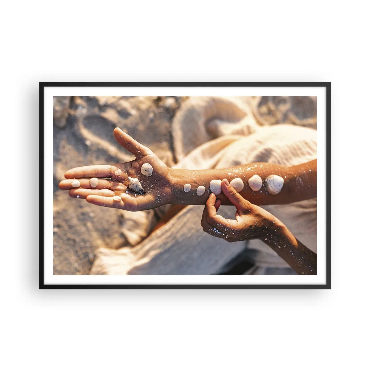 Poster in einem schwarzem Rahmen - Hände mit Muscheln auf dem Sandhintergrund angeordnet - 100x70cm - Schönheit an Ihren Fingerspitzen - Moderne Wanddekoration für Wohnzimmer und Schlafzimmer ARTTOR