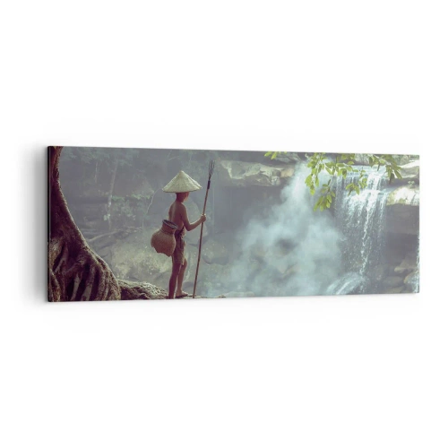 Bild auf Leinwand - Leinwandbild - Eine Figur mit einem Speer an einem Wasserfall in einem tropischen Wald - 140x50cm - Befreundet mit der Natur - Moderne Wanddekoration für Wohnzimmer und Schlafzimmer ARTTOR