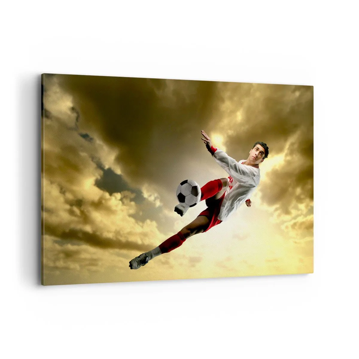 Bild auf Leinwand - Leinwandbild - Ein Fußballspieler in einem dynamischen Sprung kickt den Ball in den Himmel - 120x80cm - Fußballhimmel - Moderne Wanddekoration für Wohnzimmer und Schlafzimmer ARTTOR