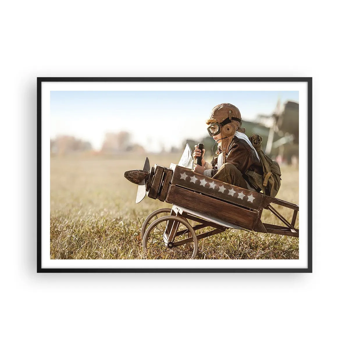 Poster in einem schwarzem Rahmen - Ein Kind in einem Spielzeugflugzeug mit einem Feld im Hintergrund - 100x70cm - Start in Richtung eines Traums - Moderne Wanddekoration für Wohnzimmer und Schlafzimmer ARTTOR