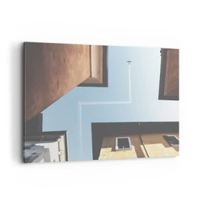 Bild auf Leinwand - Leinwandbild - Blick auf das Flugzeug und seine Spur am Himmel aus der Straßenperspektive - 100x70cm - Über dem Stadtlabyrinth - Moderne Wanddekoration für Wohnzimmer und Schlafzimmer ARTTOR